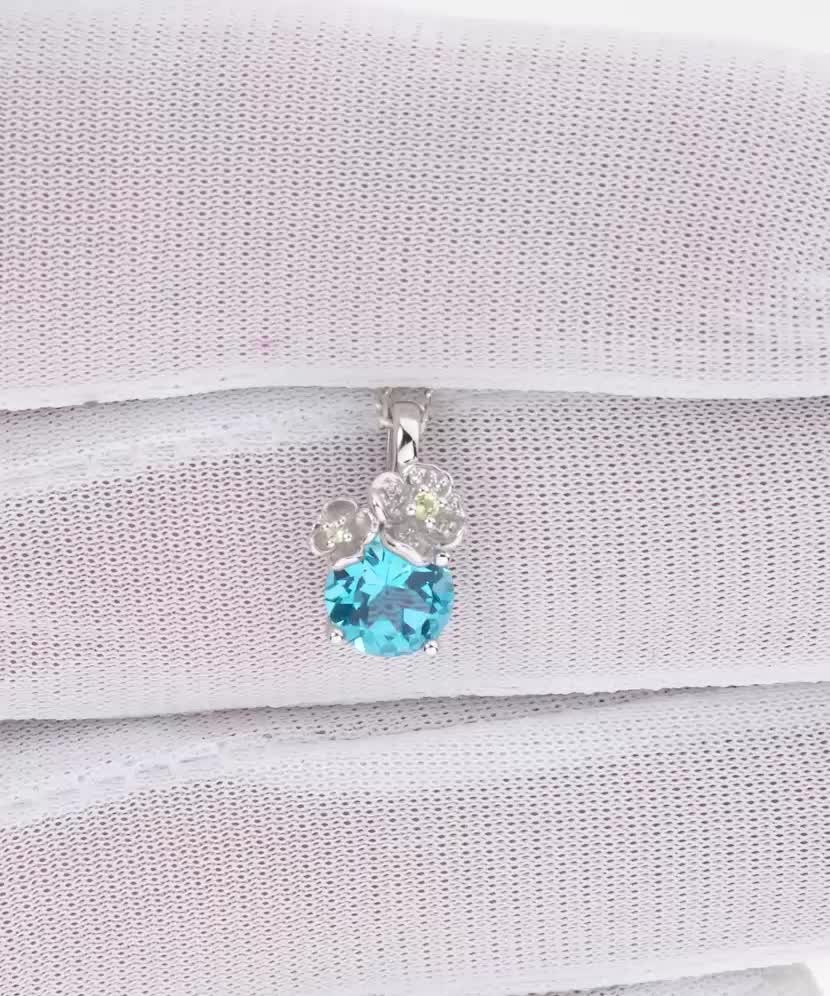 Balto aukso pakabukas su topazu, deimantais ir peridotais